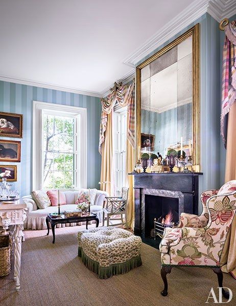 a living room filled with furniture and a fire place next to a mirror on the wall