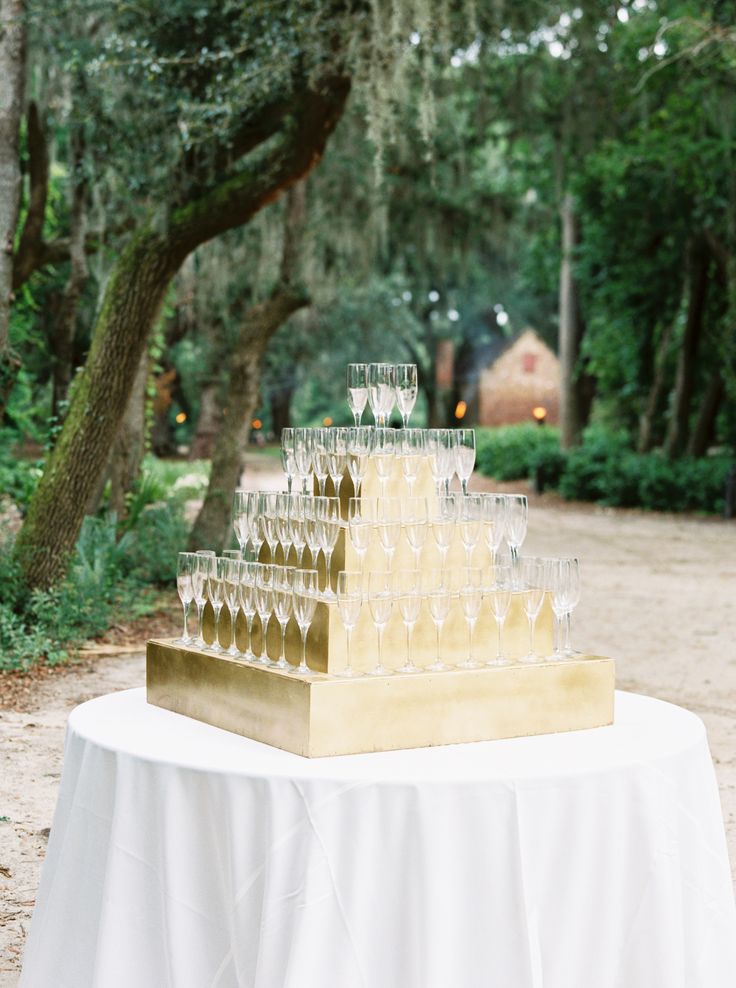 This gold display is a beautiful way to serve your bubbly for your wedding. Champagne towers are glamorous and make a statement at the entrance of your reception, and definitely a totally camera-ready. This is one of my favorite wedding Champagne tower ideas. Perfect for your cocktail hour and an elegant way to toast the newlyweds. Another ideas is to showcase your champagne glasses with your seating display. Place the escort cards directly on the glass for your guests, an elegant display. Champagne Flute Stand, Wedding Entrance Champagne, Champagne Wedding Entrance, Champagne Toast Display, Champagne Glass Display Party Ideas, Champagne Table Display Wedding, Champagne Serving Ideas, Cocktail Hour Drink Display, Champagne Entrance Wedding