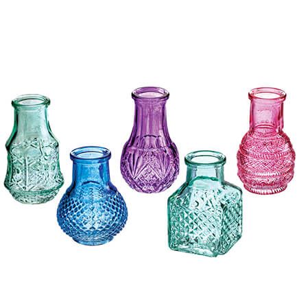 four different colored glass vases sitting next to each other