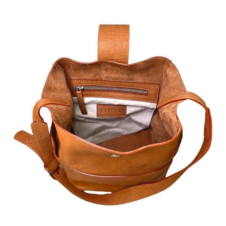 Andes is a deep, bucket style bag; everything you need for a busy day. It features a large unlined main compartment, with a magnetic closure and an inner zippered pocket. On the outside, it has three flat pockets to keep essentials handy. Adjustable strap makes it perfect to use as a shoulder bag or across your body. It is made with 100% Argentinian vegetable tanned leather, which makes it extremely smooth and soft to the touch. Available in caramel. Dimensions: 9'(width) x 12' (height) x 6' (de Luxury Bucket-shape Shoulder Bag For On-the-go, Modern Bucket Bag With Leather Handles For On-the-go, On-the-go Bucket Bag With Leather Handles, Modern Bucket Bags For On-the-go, Leather Bucket Satchel For On-the-go, Luxury Bucket Bag With Detachable Strap For Everyday, Luxury Large Capacity Bucket Bag For On-the-go, Luxury Bucket Bag With Adjustable Strap For Travel, Luxury Travel Bucket Bag With Adjustable Strap