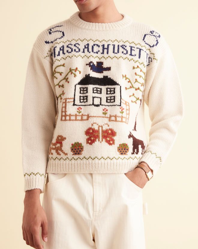 a man wearing a sweater with an image of a house on it