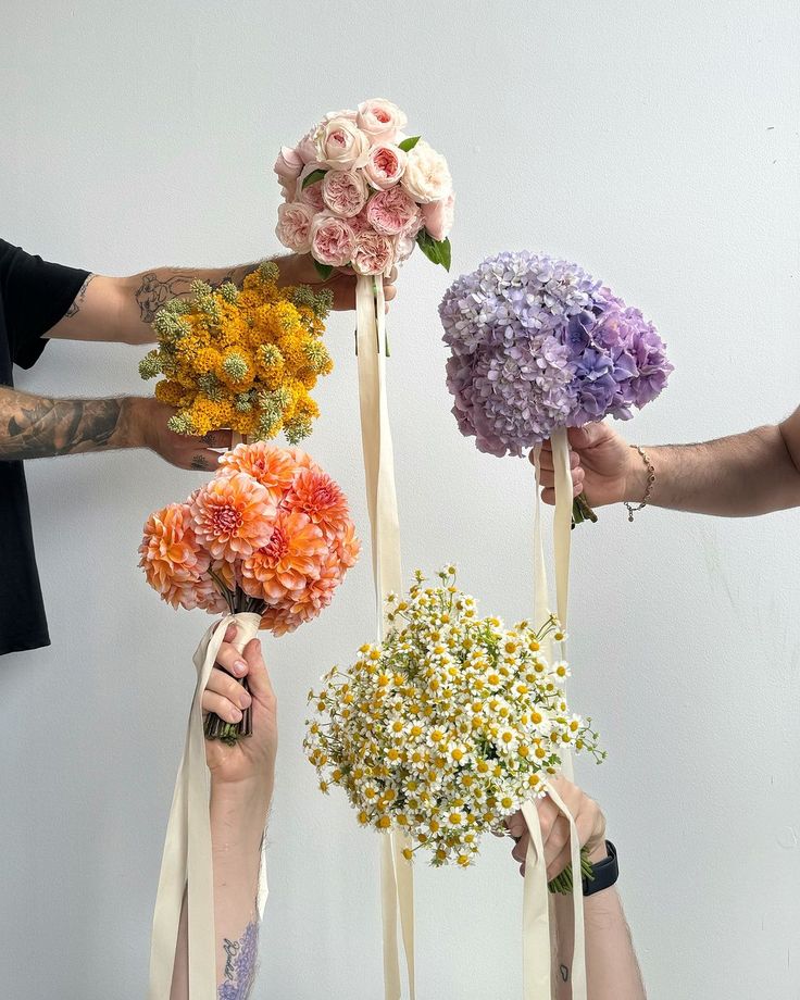 four people holding flowers in their hands