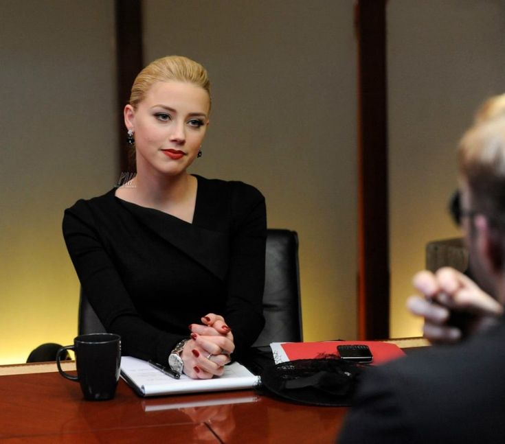 a woman sitting at a desk in front of a man