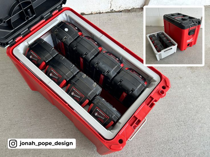 a red case filled with lots of black and red batteries on the floor next to a white wall