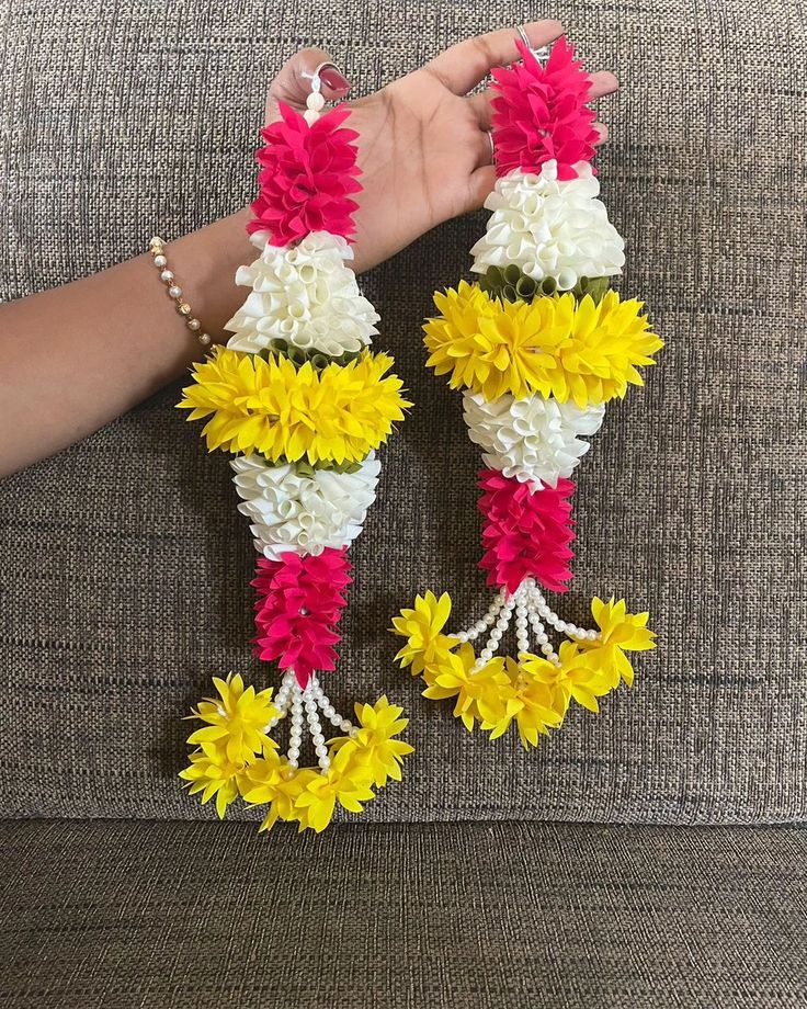 two handmade flower vases sitting on top of a couch