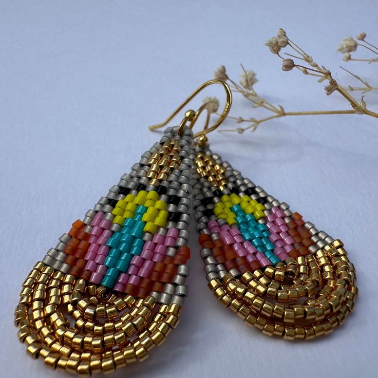 Introducing the "Lotus Gold" earrings, a dazzling fusion of vibrant colors and elegant design. These handcrafted earrings are inspired by the beauty of lotus flowers and crafted with meticulous attention to detail. Materials: High-quality seed beads in various colors, silver and gold tone sterling silver 925 ear hooks. Weight: 2g each Length:  5.5 cm Width: 2 cm Care Instructions: To maintain the beauty of your earrings, avoid direct contact with water, perfume, and harsh chemicals. Store them i Water Perfume, Lotus Flowers, The Lotus, Delica Beads, Handcrafted Earrings, Sterling Earrings, Beaded Earrings, Silver 925, Favorite Jewelry