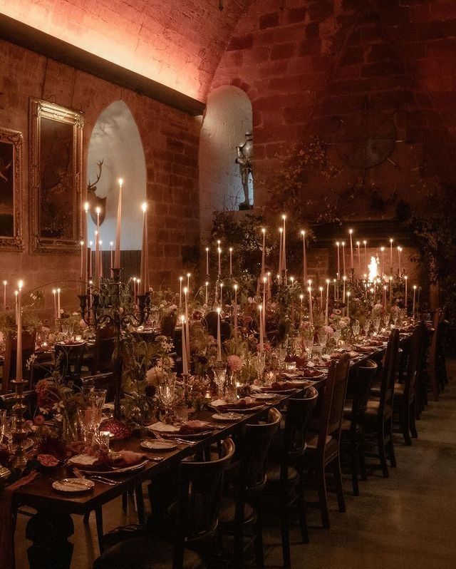 a long table is set with many candles and place settings for an event or gathering