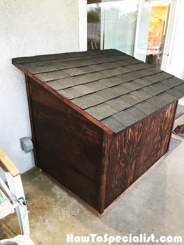 a wooden box sitting on top of a cement floor next to a door and window