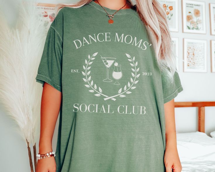 Celebrate with your fellow Dance Moms in style with this beautiful simple Dance Mom's Social Club Sweater. These make a great purchase for yourself or for all the Dance moms for your team!   The Comfor Color Shirts are soft and excellent quality. You'll not be disappointed! How to Order 1. Select Color and Size 2. Add personalization in the box.  3. Add to cart 4. Repeat until all items for your dance crew are in the cart 5. Proceed to checkout.  6. Await your beautiful personalized items! 💖 Thanks for stopping by Cheeky Trove! We appreciate every customer! 🎁 Our sweatshirts are a sturdy and warm sweatshirt bound to keep you warm in the colder months. A pre-shrunk, classic fit sweater that's made with air-jet spun yarn for a soft feel and reduced pilling. 🎁 Cheeky Trove designs are a pe Summer Dance Class Crew Neck T-shirt, Summer Crew Neck T-shirt For Dance Class, Summer Crew Neck Tops For Dance Class, Crew Neck Tops For Dance Class Summer, Graphic Print T-shirt For Dance Class In Summer, Dance Crew, Simple Dance, Dance Mom, Mama T Shirt