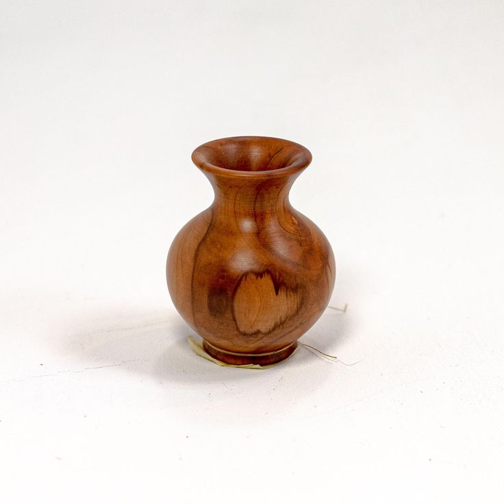 a wooden vase sitting on top of a white table