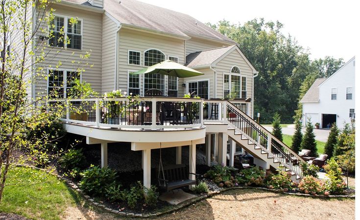 a large white house with an umbrella on the balcony