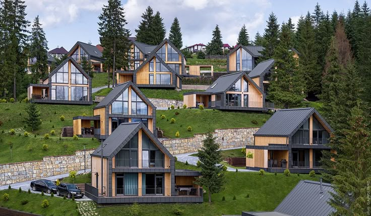 many wooden houses on a green hillside surrounded by trees