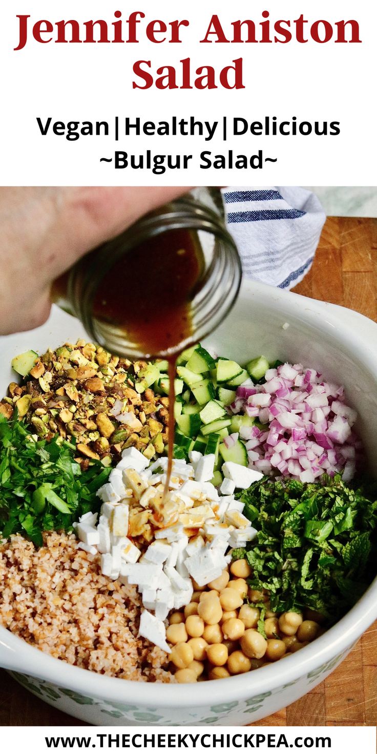 a person pouring dressing into a bowl filled with vegetables and other ingredients to make a salad