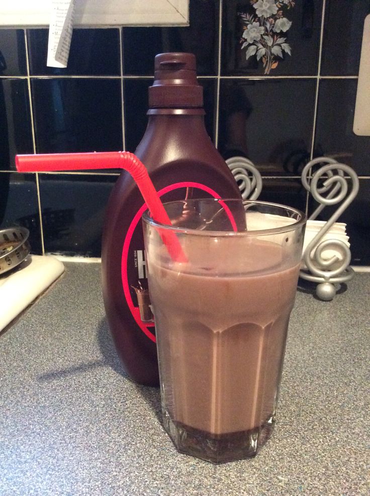 a chocolate drink with a red straw sticking out of it sitting on a kitchen counter