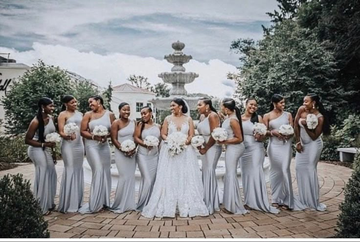 a group of women standing next to each other on top of a brick floored walkway