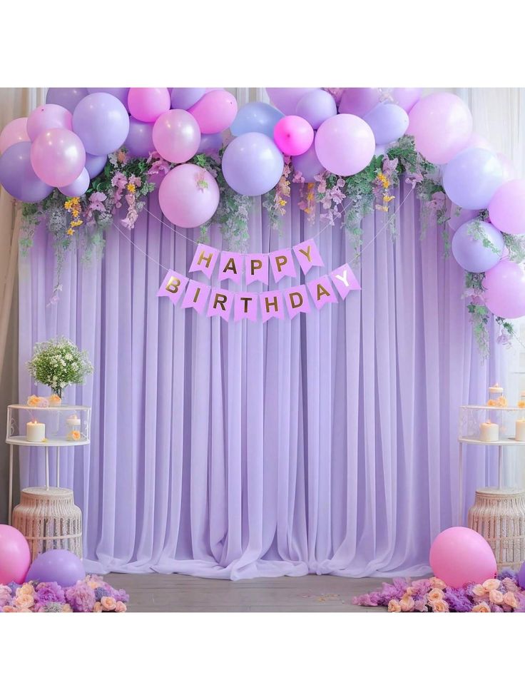 a purple and pink birthday party with balloons, streamers and flowers on the wall