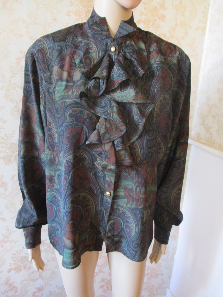 "fabulous silk mix paisley shirt with a high neck and a ruffled front.  It has long blouson sleeves with silver buttons to close and on the cuffs.  There is slight padding on the shoulders which is removeable,  the pattern is paisley with a subtle hunt pattern.  Very good condition. Bust flat;  22\" Inside sleeve;  19\" Length;  28\" Made by BLEU MARINE DESIGN" Fitted Paisley Print Blouse For Work, Victorian Long Sleeve Tops For Fall, Fitted Long Sleeve Blouse With Paisley Print, Formal Paisley Print Tops For Spring, Fitted Victorian Ruffle Top, Fall Blouse With Ruffles And Tie Neck, Fitted Tie Neck Top With Ruffles, Fall Tie Neck Blouse With Ruffles, Fitted Ruffle Tie Neck Top