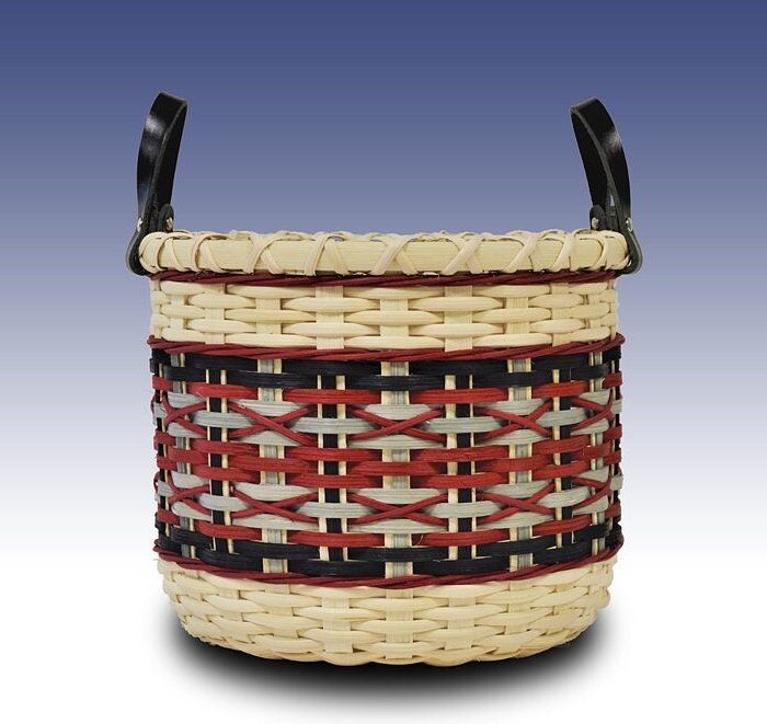 a woven basket with handles is shown against a blue background and has black handles on it