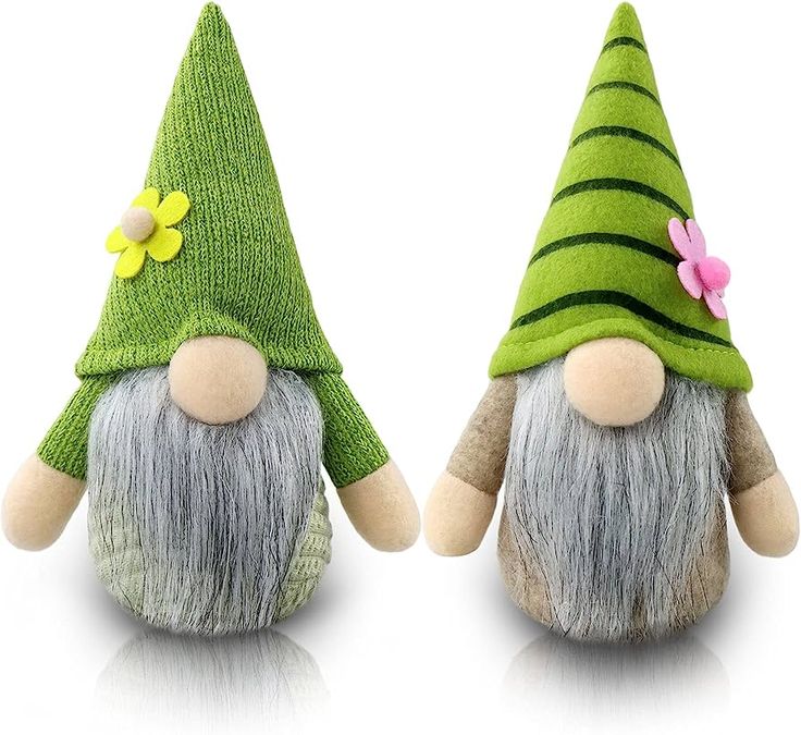 two small stuffed gnomes with green hats and flowers on their heads are facing each other