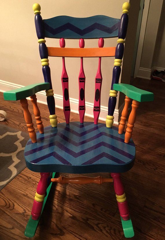 a child's rocking chair made out of wooden sticks and painted with colorful paint