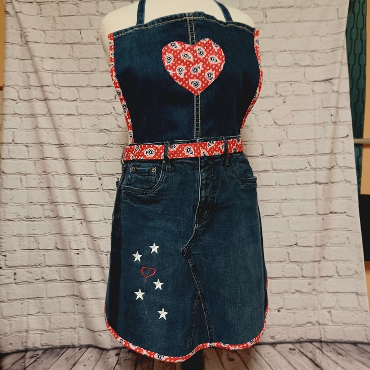 a woman's denim apron with an embroidered heart on it