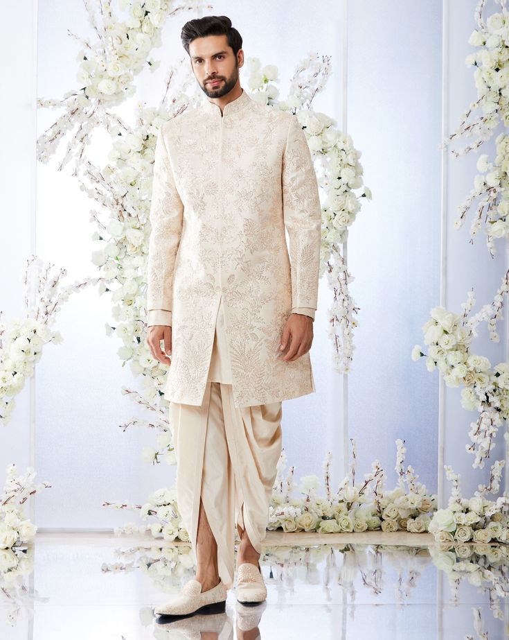 This rose gold sherwani set features all over gota embroidery on a raw silk base. It is paired with a detailed cotton silk kurta and a dhoti pant. Complimenting footwear is also available.From Seema Gujral's Tuscan Summer collection. DELIVERY TIMEPlease allow 8-12 weeks for your outfit to arrive.FABRIC DETAILSRaw SilkProfessional cleaning only. Diwali Reception Bandhgala With Gota Work, Bandhgala With Gota Work For Diwali Reception, Bandhgala For Reception With Gota Work For Diwali, Bandhgala With Gota Work For Diwali, Elegant Sherwani With Gota Work For Ceremonial Occasions, Ceremonial Bandhgala With Gota Work, Eid Raw Silk Sherwani With Gota Work, Designer Wear Sherwani With Gota Work And Straight Kurta, Designer Sherwani With Gota Work In Straight Kurta Style