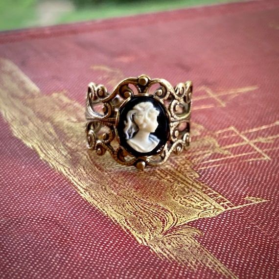 Victorian style antiqued brass filigree ring which is fully adjustable.At its center is a 10x8mm black and white womans profile cameo.   Other cameo color options are available as well.Also available in antiqued silver. Womans Profile, Gold Marquise Ring, Silver Celtic Rings, Opal Solitaire Ring, Turquoise Statement Ring, White Lady, Purple Lady, Wholesale Jewelry Supplies, Turquoise Gold Ring