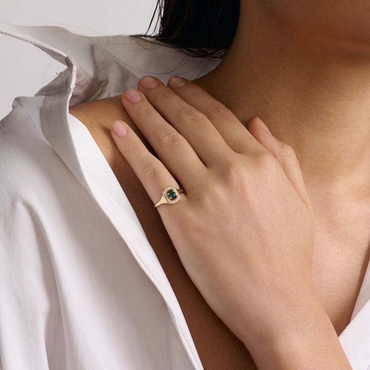 For this ring we have returned to another ring inspired by the details of tailoring. We have reversed the balance of power with this ring, bringing the button, an often forgotten detail to the center of this ring. We have played with the positive and negative spaces of a button by placing the central emerald within a frame of smaller stones. We love the strength and subtlety of this shape and how your skin will show through when wearing it. The femininity of the central stone, against the frame, offers the contrast between masculine and feminine energies. All features can be customized! Please contact us if you wish to make changes, we love making custom designs. All of our jewelry is carefully handmade in our atelier. *HC diamond are all conflict-free diamonds To order by phone 972-72-299 Timeless Yellow Gold Signet Ring With Emerald, Timeless Yellow Gold Emerald Signet Ring, Timeless Emerald Rings With Bezel Setting, Timeless Emerald Signet Ring For Anniversary, Timeless Emerald Cut Birthstone Ring In 14k Gold, Elegant Emerald Ring With Bezel Setting, Timeless Yellow Gold Emerald Ring, Timeless Emerald Cut May Birthstone Rings, Elegant Diamond Halo Ring With Birthstone