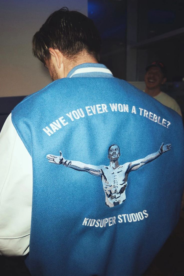 the back of a man wearing a blue jacket with an image of jesus on it