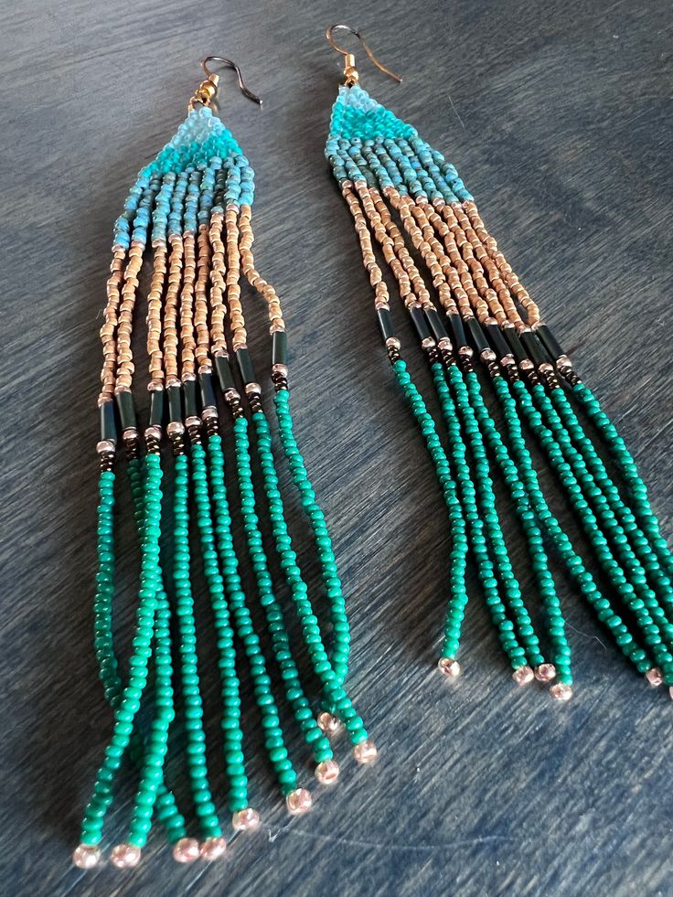 These gorgeous long turquoisey earrings will be sure to make a statement with any outfit. They would make a great Christmas gift for the earring lover in your life. These earrings hold two different size seed bead to give them a unique texture and look that make them stand out from my more traditional designs. Turquoise Tassel Earrings With Colorful Beads For Festival, Festival Turquoise Tassel Earrings With Colorful Beads, Turquoise Beaded Earrings With Dangling Beads For Festivals, Turquoise Beaded Drop Earrings For Festival, Festival Turquoise Beaded Drop Earrings, Turquoise Beaded Tassel Earrings For Festival, Turquoise Tassel Earrings With Colorful Beads For Beach, Unique Turquoise Beaded Earrings, Festival Turquoise Earrings With Tiny Beads