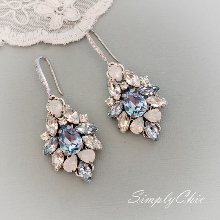 Elegant Vintage style Bridal Earrings. Made with high-quality Swarovski rhinestones in light blue and clear crystals, finished with elegant crystallized french hooks. Designed and created in SimplyChic studio Matching necklace available at this link: https://www.etsy.com/listing/782914818/sapphire-light-blue-statement?ref=shop_home_active_2&frs=1 Matching bracelet: https://www.etsy.com/listing/786999339/sapphire-light-blue-statement?ref=shop_home_active_43&pro=1&frs=1 Matching hair a Blue Rhinestone Crystal Earrings For Wedding, Blue Crystal Earrings For Wedding, Blue Crystal Dangle Bridal Earrings, Blue Cubic Zirconia Crystal Earrings For Wedding, Elegant Jeweled Blue Crystal Earrings, Elegant Blue Jeweled Crystal Earrings, Elegant Blue Crystal Chandelier Earrings, Blue Crystal Bridal Earrings, Blue Crystal Bridal Earrings With Matching Set