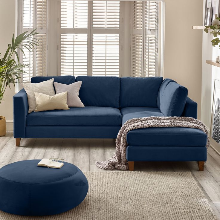 a living room with a blue couch and ottoman