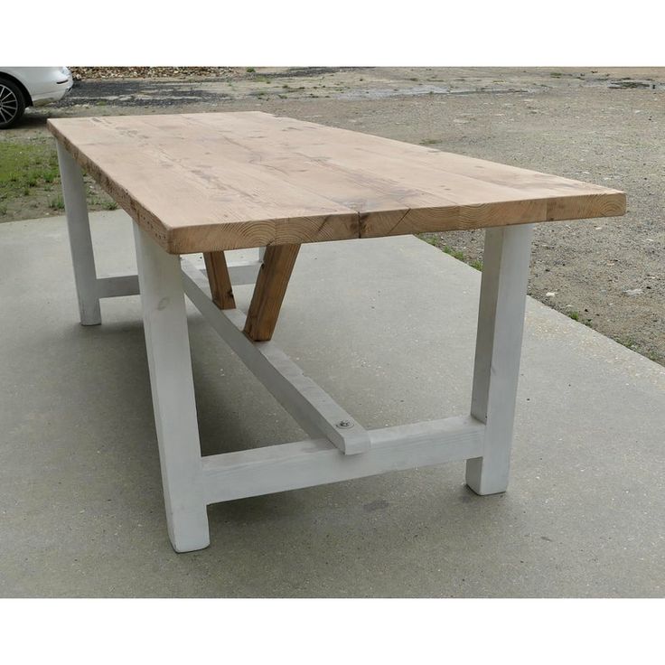 a wooden table sitting on top of a cement ground