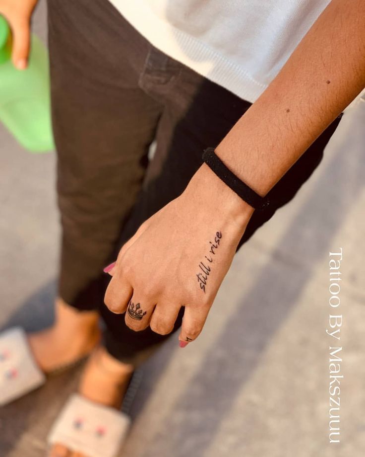 a person with a small tattoo on their left wrist and foot is holding onto a skateboard