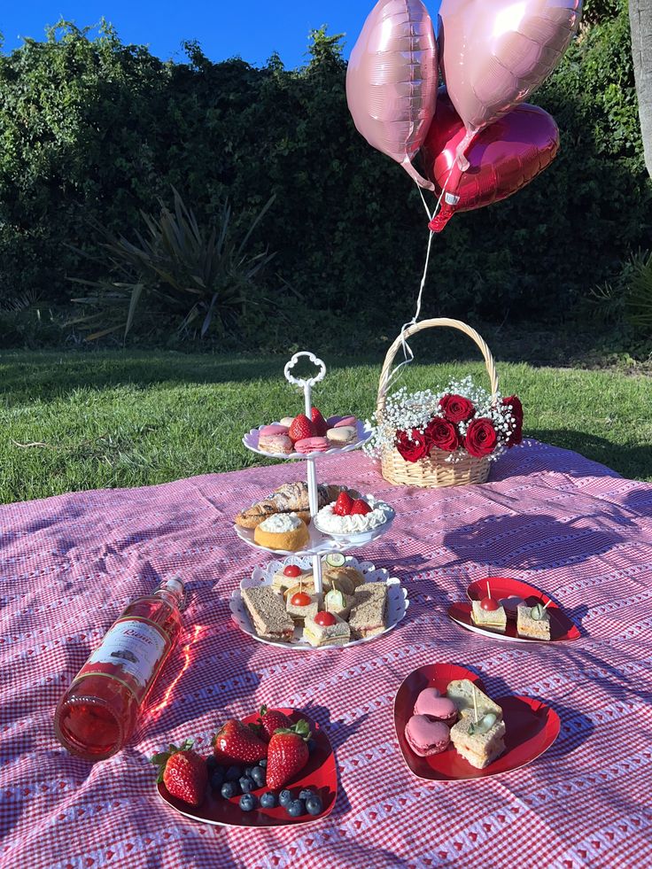 a picnic table with food and balloons on it