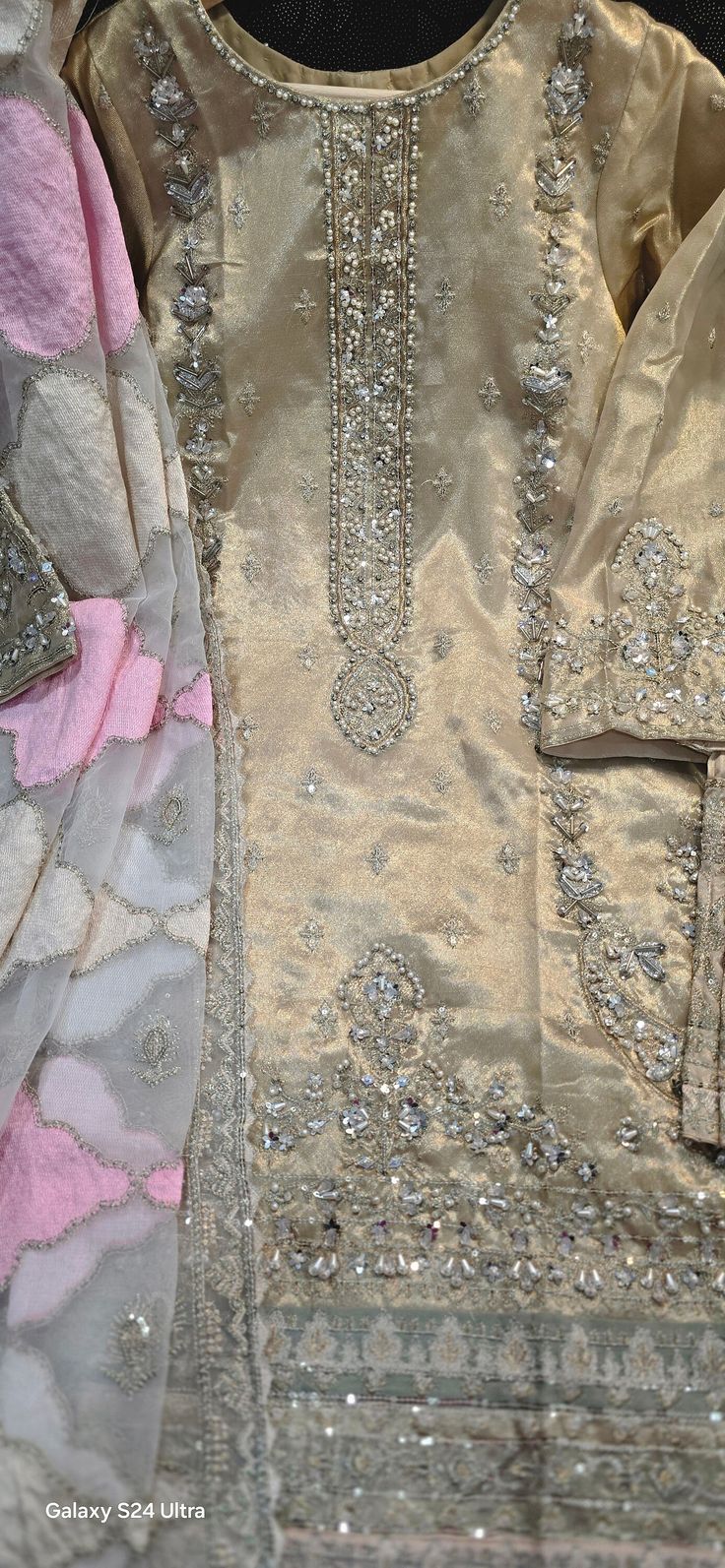 **Gorgeous Sharara Sajal Ali Viral Dress** The "GOLDEN FAIRY" dress is even more stunning in person than in pictures. **Features - Fully embroidered kameez with tillah work and sequins, including the back. - Beautifully embellished dupatta border with sequins work and lace, as well as full dupatta embroidery with heavy string work. - Embroidered front pant to complete the look. - Hand work on the sleeves and kameez. **Available Sizes - Small - Medium Thank you for your continued support of n_to_ Semi-stitched Gold Chanderi Lawn Suit, Party Sharara With Gold Embroidery, Anarkali Salwar Kameez With Gold Embroidery For Eid, Party Semi-stitched Sharara With Gold Embroidery, Elegant Salwar Kameez With Gold Embroidery For Festivals, Bollywood Style Gold Embroidered Sharara For Party, Traditional Gold Jamawar Dress, Festive Traditional Wear With Gold Embroidery For Party, Semi-stitched Gold Embroidered Sharara For Party