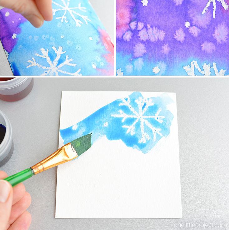 someone is painting snowflakes on paper with watercolors and then using a paintbrush