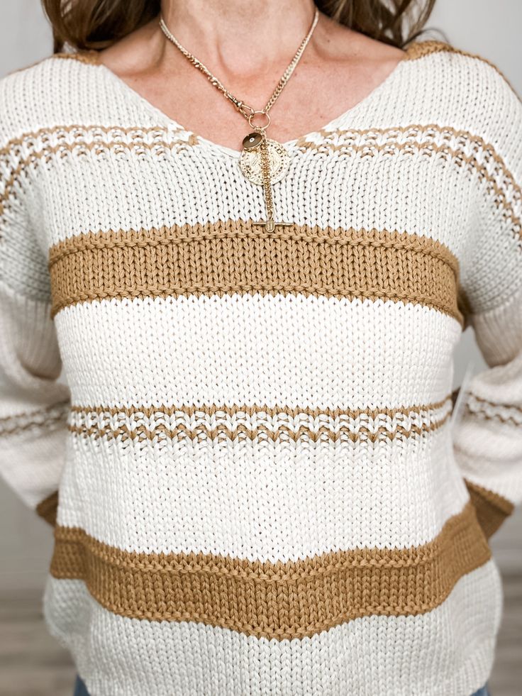 a woman wearing a white and brown striped sweater