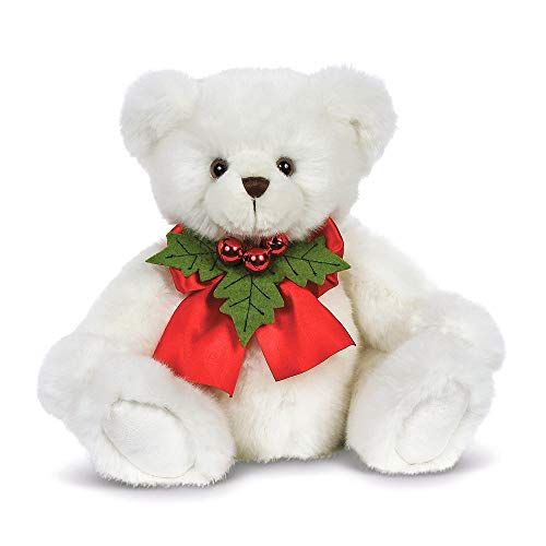 a white teddy bear with a red bow and holly decoration on it's neck