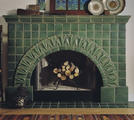 the fireplace is decorated with green tiles and wood