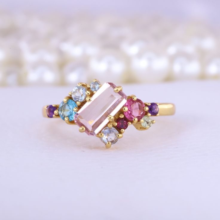 Emerald Cut Pink Sapphire Cluster Ring Multi Gemstone Engagement Ring 18K Yellow Gold Jewelry Art Deco Bridal Ring Anniversary Gift For Wife Description: Main Stone - Sapphire Stone Size - 7 x 5 MM Stone color - Pink Main Stone creation - Lab Created Stone shape - Emerald  Birthstone - September Secondary Stone - Multi Gemstone (Ruby, Aquamarine, Topaz, Amethyst) Stone Color - Multi Color Stone Shape - Round Finishing- Excellent feel free to contact me if you have any questions  Gemstone color m Pink Multi-stone Amethyst Ring, Gold Multi-stone Birthstone Ring, Gold Multi-stone Gemstones For Wedding, Pink Multi-stone Cluster Ring As A Gift, Morganite Multi-stone Anniversary Rings, Morganite Multi-stone Rings For Anniversary, Gold Multi-stone Topaz Ring, Gold Multi-stone Amethyst Ring Fine Jewelry, Pink Multi-stone Amethyst Ring Gift