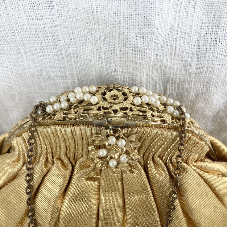 "An eye-catching vintage evening bag in shimmering gold! Likely from the late 1930s/early 1940s. The tops of the pleats show wear at the edge of the gathers. It is lined in a pale tawny satin with internal pockets. Interior is clean, but does have a few small snags. Interior tag for \"Ed B. Robinson\". Chain strap is tarnished. Note that the photos show the bag stuffed with tissue. There are a few light horizontal fold in the gold fabric from improper storage (see photos.)" Antique Style Evening Clutch Bag, Mid-century Gold Evening Bag, Classic Beige Evening Bag, Victorian Gold Bag For Party, Vintage Beige Party Bag, Victorian Gold Party Bags, Antique Clutch Evening Bag For Vintage Events, Antique Style Clutch For Vintage Events, Vintage Evening Bag For Vintage Events