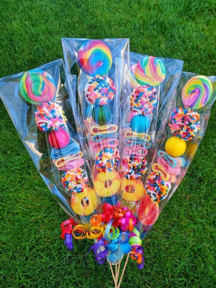 a bunch of lollipops and candy sticks on the ground in plastic bags