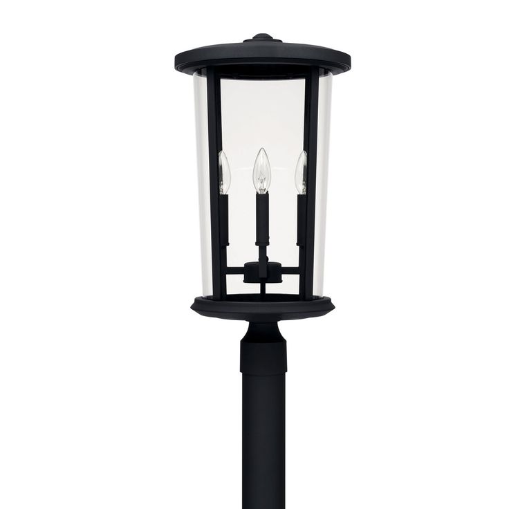 a black post light with two candles on it