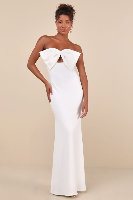 Exceptional elegance just comes naturally with a look like the Lulus Coveted Glamour White Strapless Bow Mermaid Maxi Dress! Stretchy crepe knit shapes this fabulous gown that features a sweetheart neckline (with hidden no-slip strips) and a strapless bodice adorned with a dramatic oversized bow and cute keyhole cutout below it. The high, empire-style waist tops a figure-flaunting, mermaid-style maxi skirt that falls to a sweeping maxi hem. Hidden back zipper/clasp. Fit: This garment fits true t White Formal Dress Long, Masquerade Formal, White Long Dress Formal, White Long Dresses, Prom Dresses Long Elegant, Bow Cutout, White Prom Dress Long, Maxi Dress Strapless, White Evening Gowns