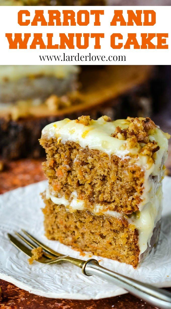 carrot and walnut cake with cream cheese frosting on a white plate next to a fork