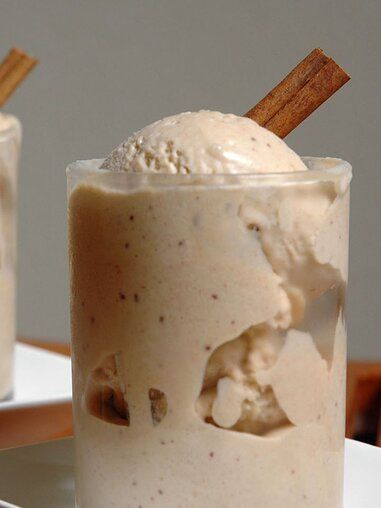 two glasses filled with ice cream and cinnamon sticks