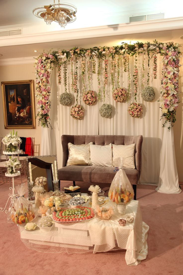 a living room filled with lots of furniture and flowers on the wall hanging from the ceiling