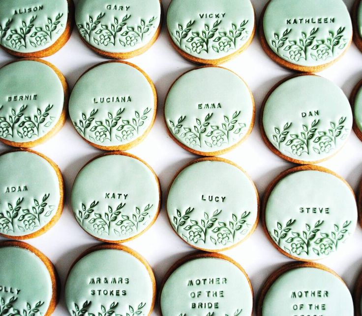 some cookies with green frosting are arranged on a white table top and decorated with leaves