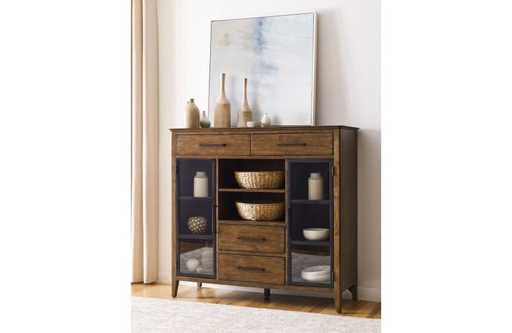 a wooden cabinet with glass doors and baskets on the bottom shelf next to a window